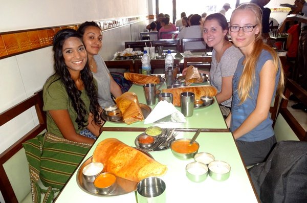 Volunteers sharing dosas at a South Indian restaurant