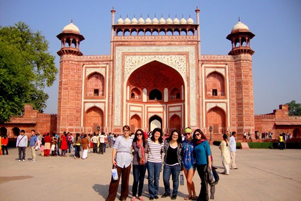 A group of volunteers at the red sandstone gateway to the Taj Mahal