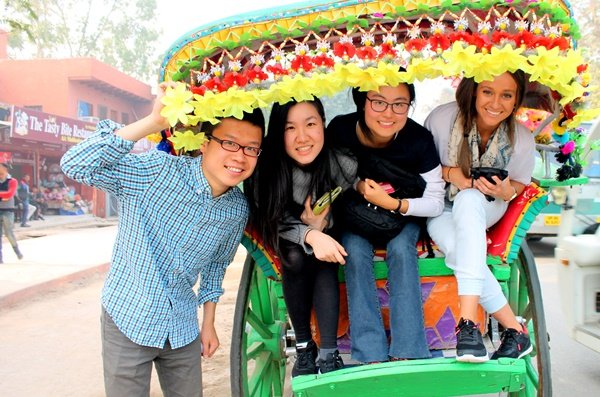 Four volunteers in a decorated cycle rickshaw