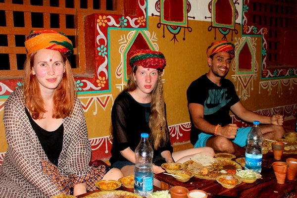 Volunteers in Rajasthani turbans sitting down to a traditional meal