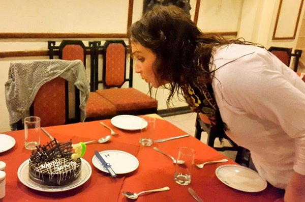 A volunteer blowing out the candle on her birthday cake