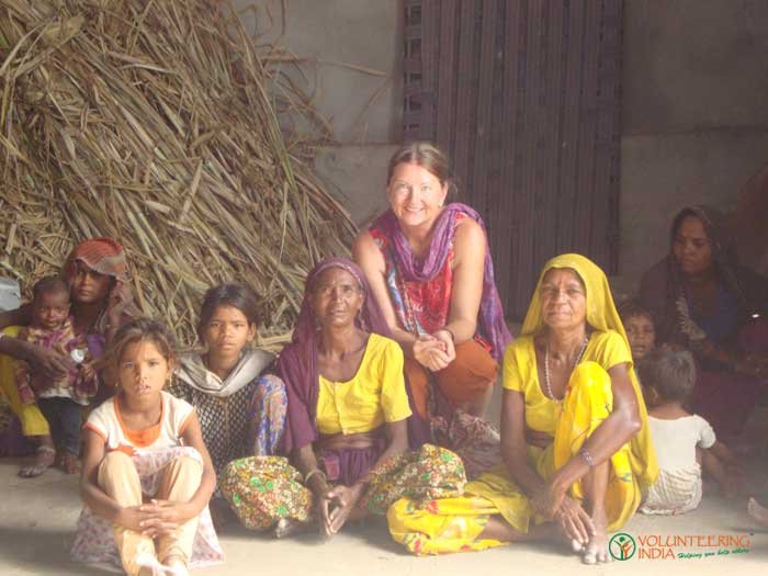A volunteer sitting with women and children from a local community
