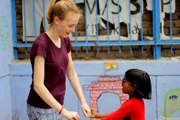 Julia holding hands with a girl outside the school in Delhi
