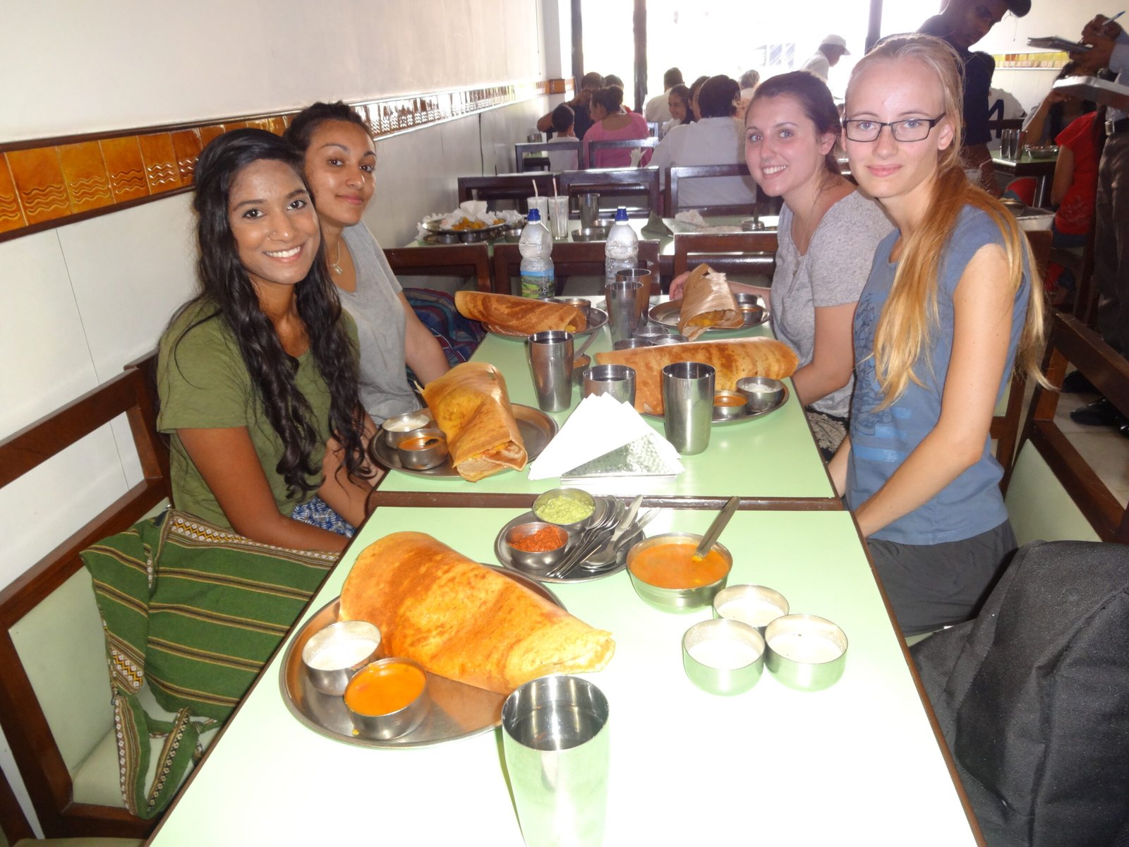 Four volunteers sharing dosas at a South Indian restaurant