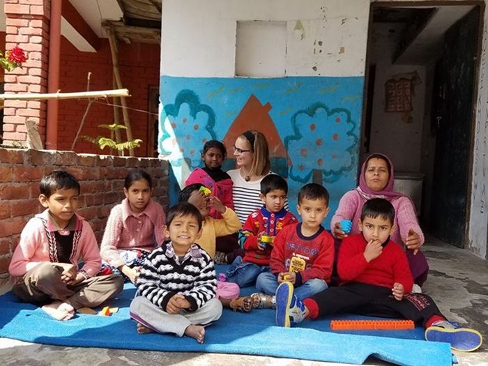 Julia with children and a staff member at a childcare center in Delhi