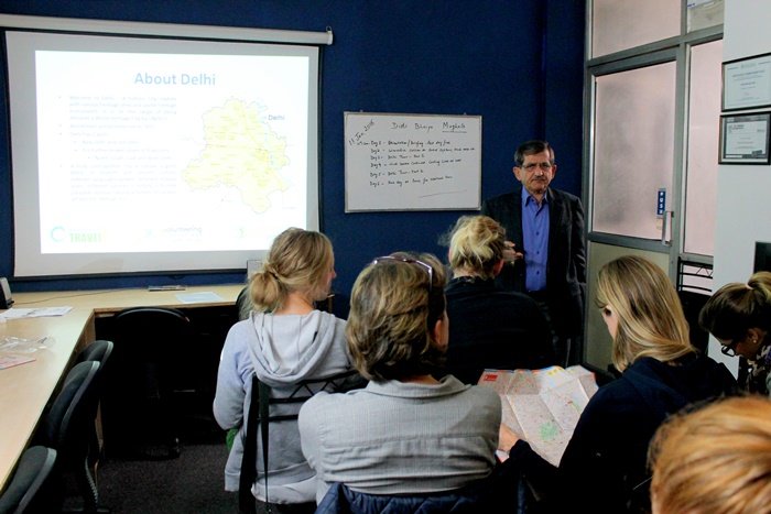 New volunteers at an orientation session, with a slide about Delhi on the screen