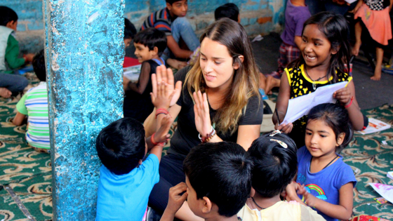 A volunteer high-fiving children at a children’s center