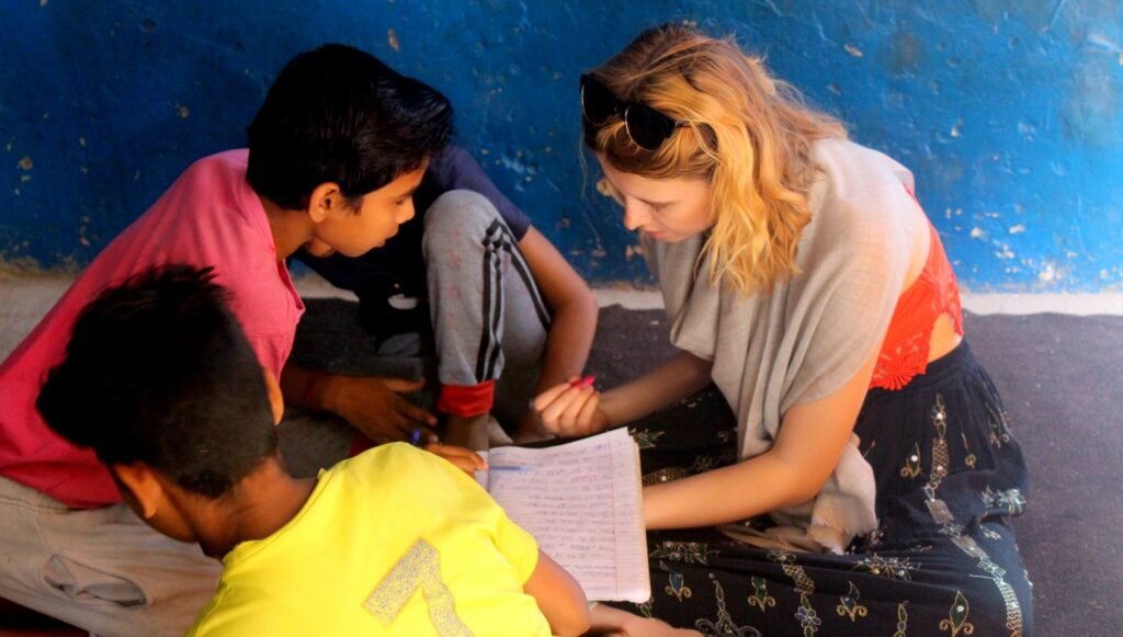 A volunteer helping two boys with their writing