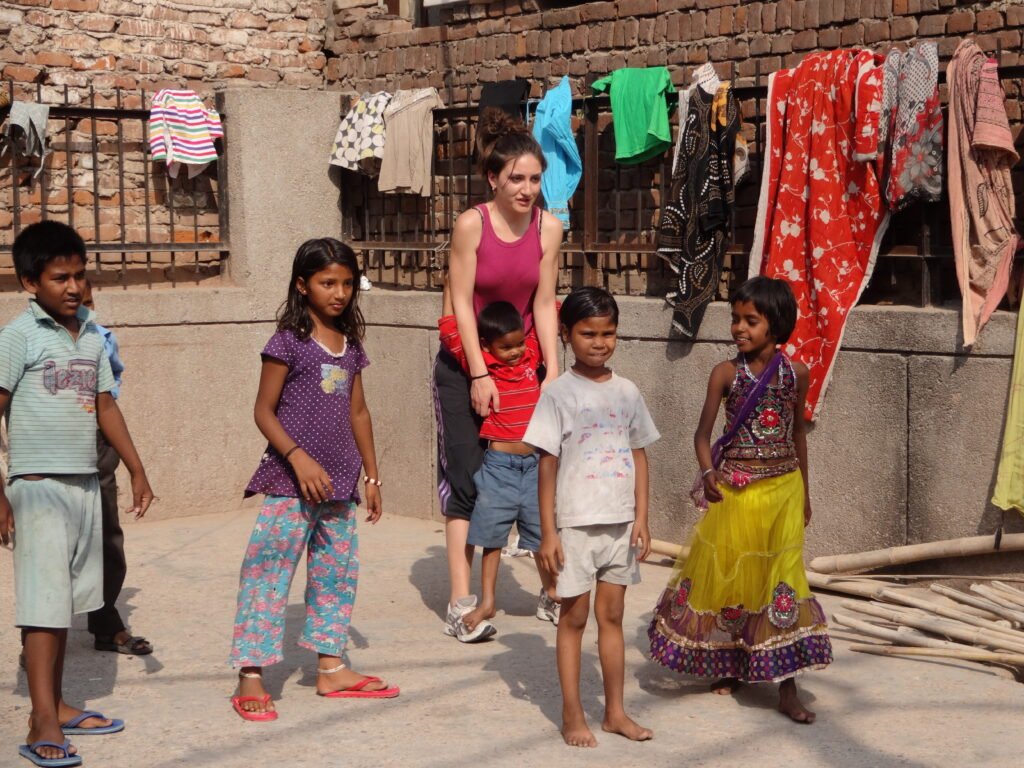 A volunteer with a group of children in a courtyard in Delhi