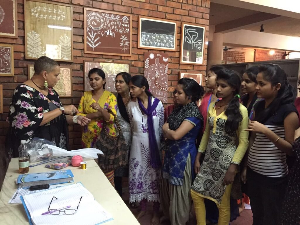 A volunteer leading a craft session with young women at a community center