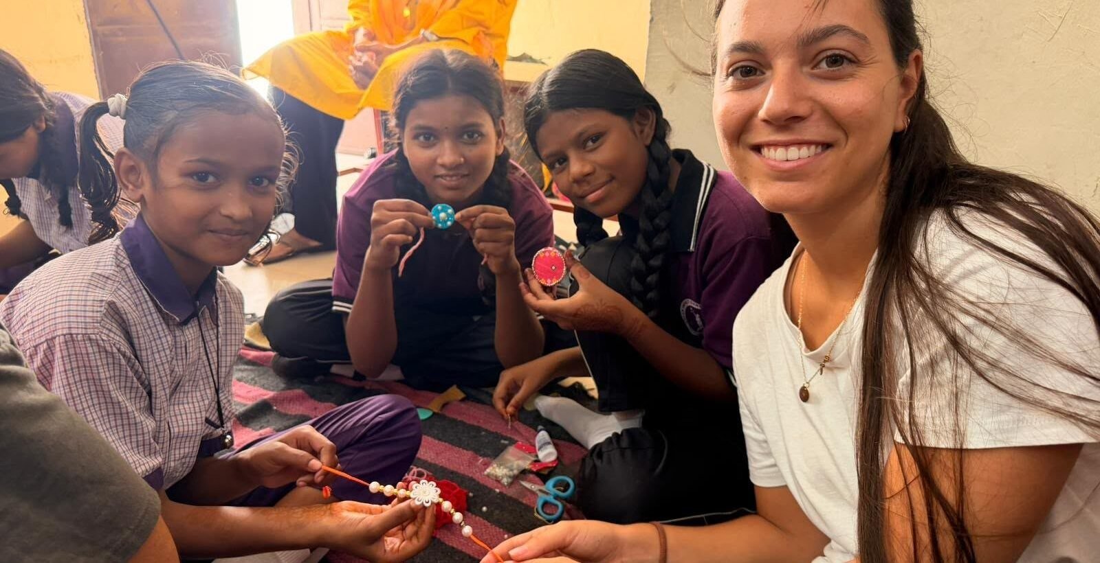 A volunteer making crafts with girls at a children’s center in Jaipur