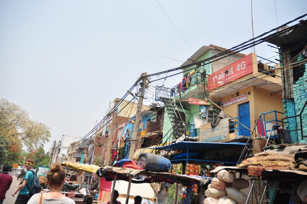 A busy street in a Delhi neighborhood, with cycle-rickshaws and small shops