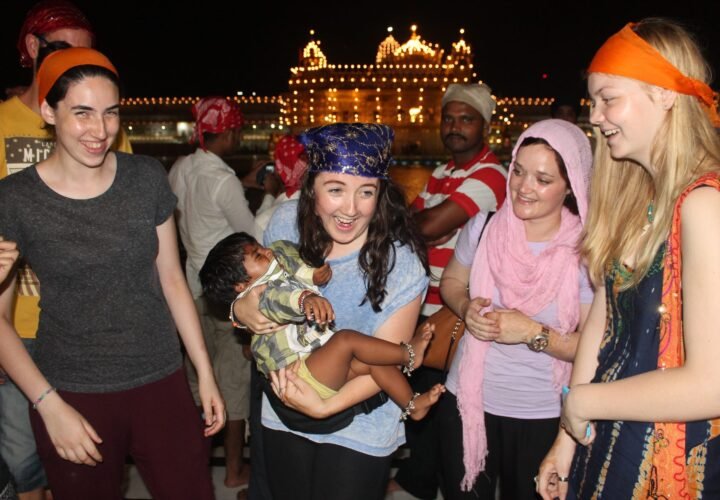 Volunteers in orange headscarves at the Golden Temple in Amritsar at night