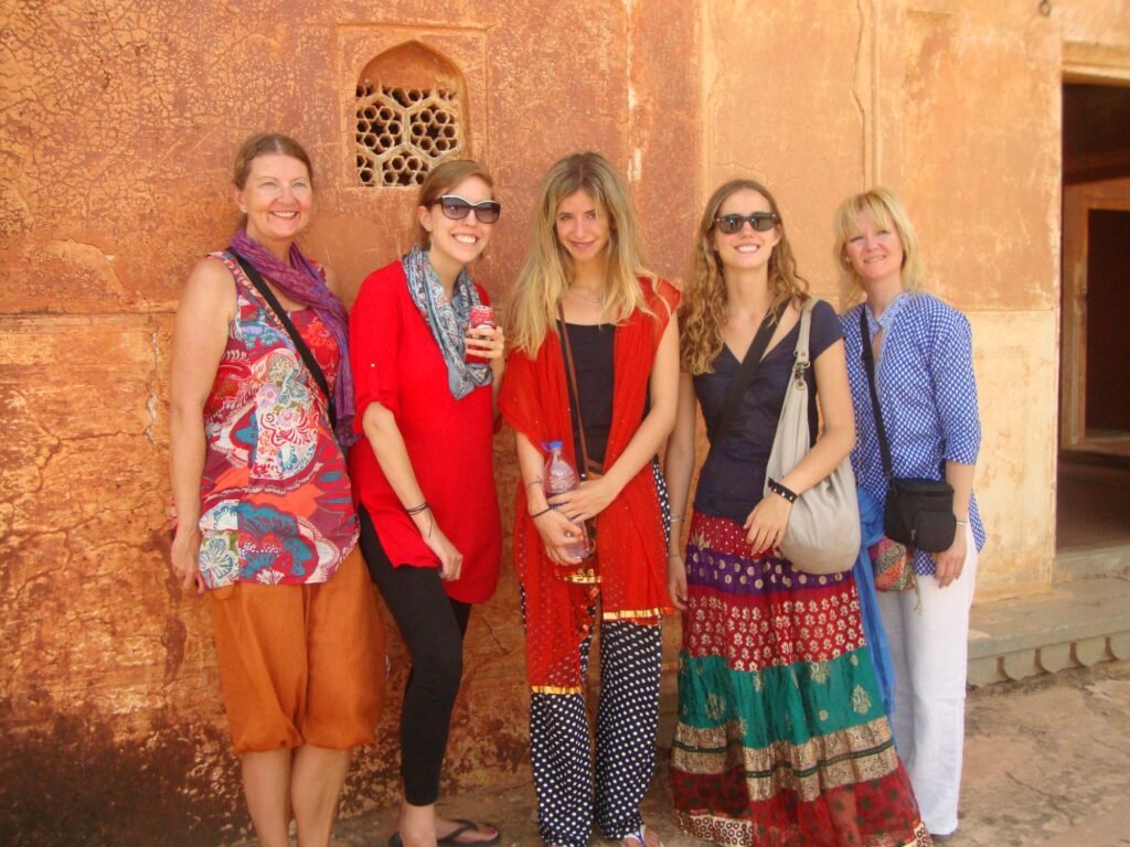 Volunteers against a sandstone fort wall on the Golden Triangle tour