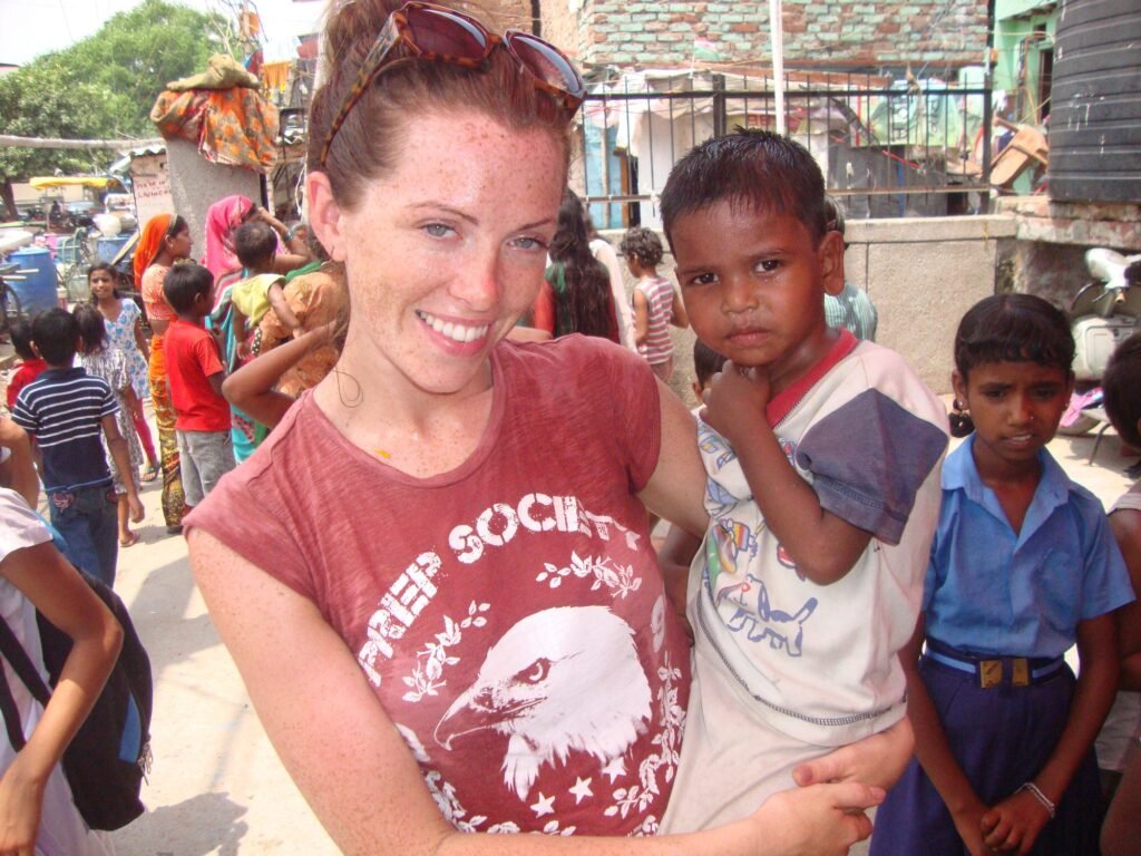 A volunteer holding a young boy during Holi at a children’s project in Delhi
