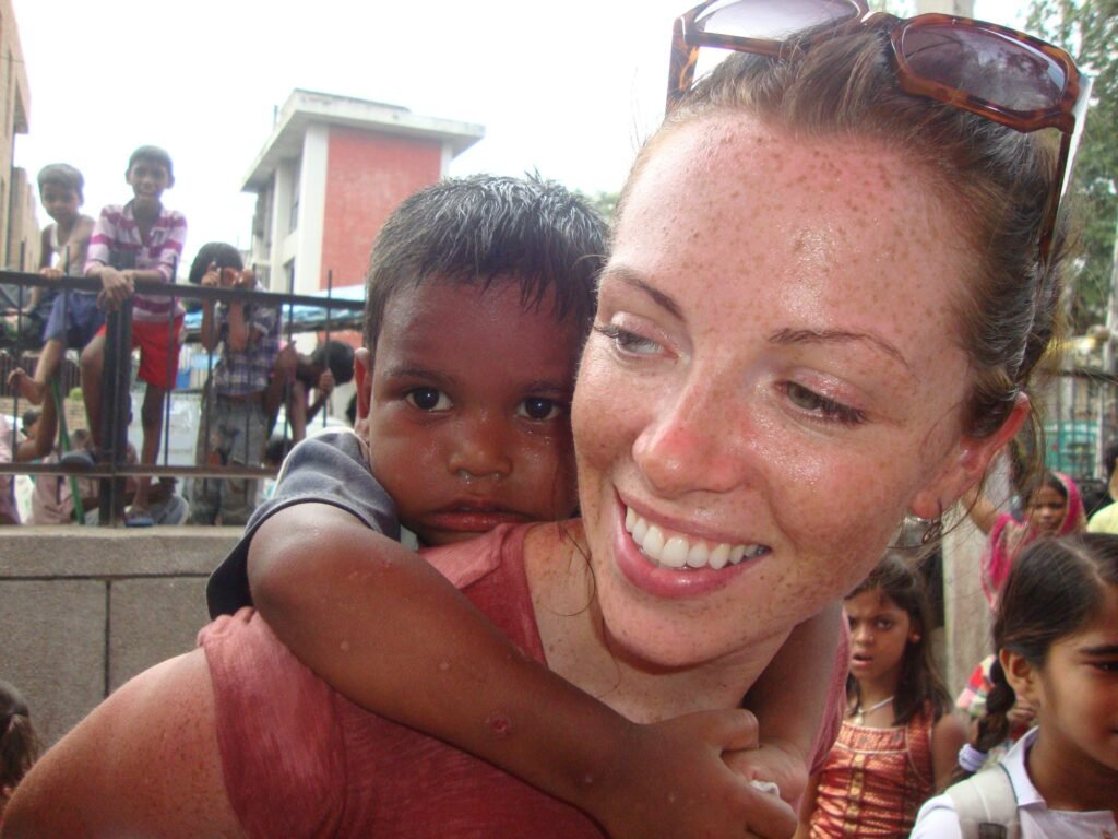 A volunteer giving a boy a piggyback ride at Holi in Delhi