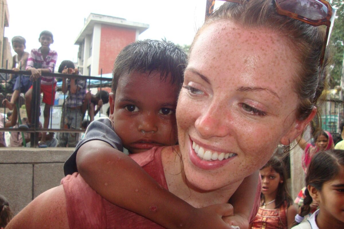 A volunteer giving a boy a piggyback ride at Holi in Delhi