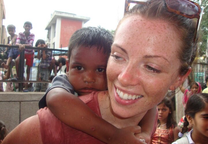A volunteer giving a boy a piggyback ride at Holi in Delhi