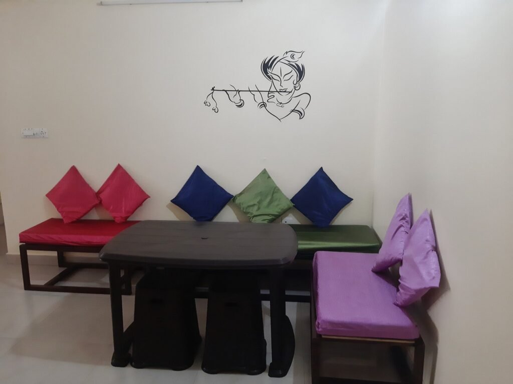 The lounge of the volunteer house in Jaipur, with low seating and bright cushions