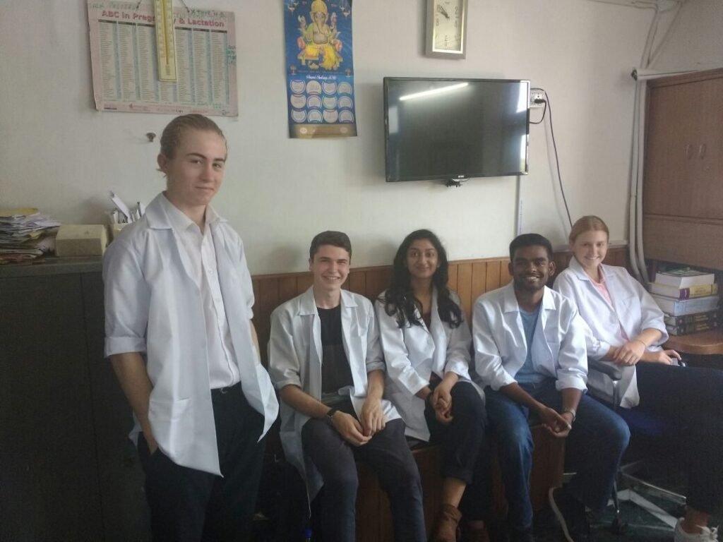 Pre-medical volunteers in white coats with doctors in Delhi