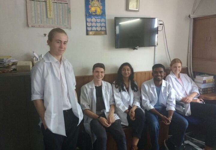 Pre-medical volunteers in white coats with doctors in Delhi
