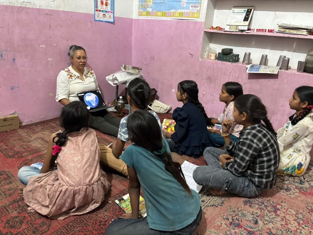 Volunteers sitting on the floor with children for a lesson in Jaipur