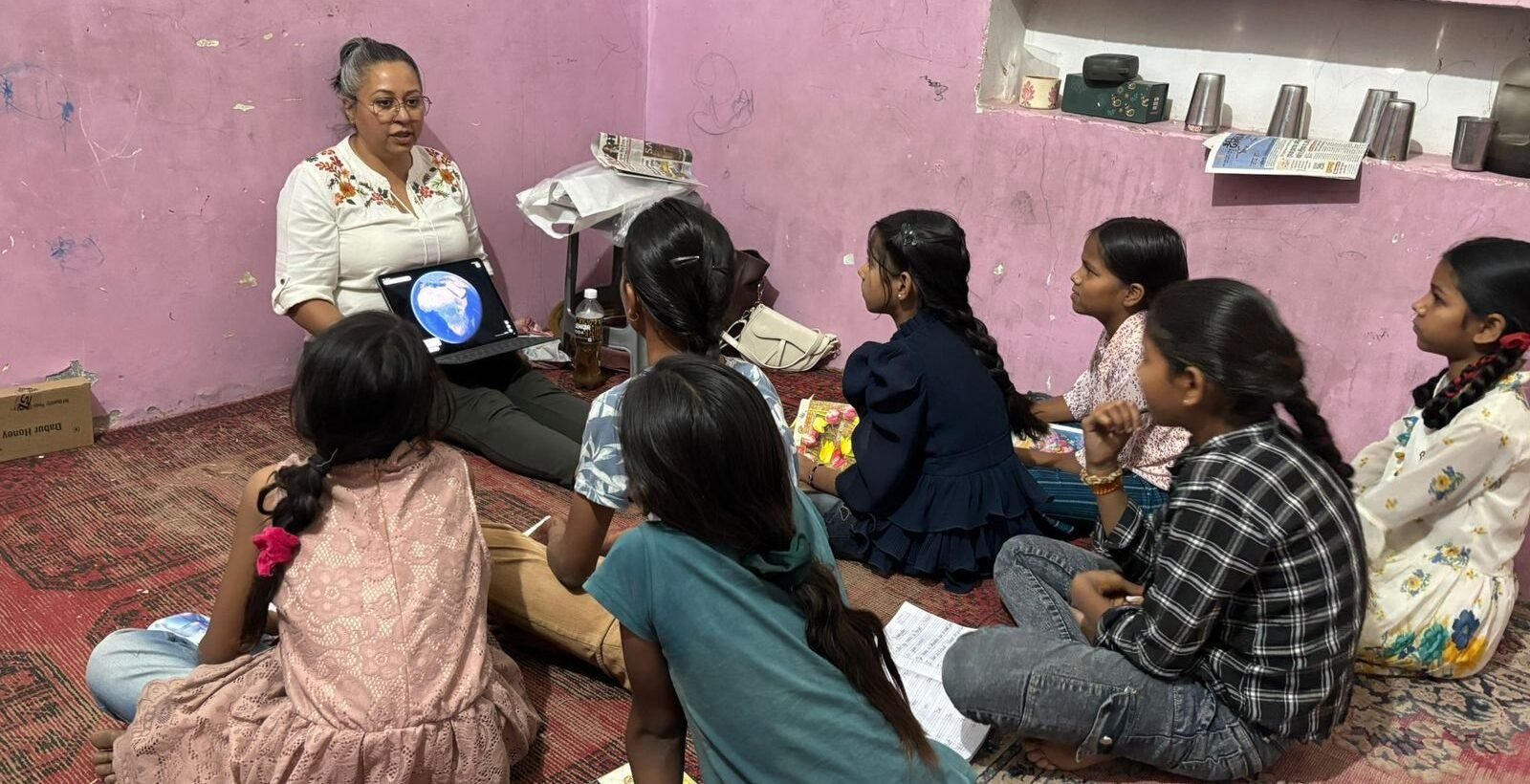 Volunteers sitting on the floor with children for a lesson in Jaipur