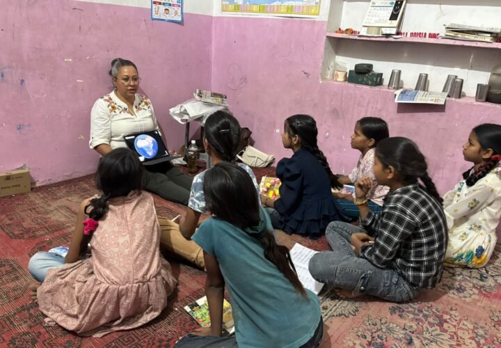 Volunteers sitting on the floor with children for a lesson in Jaipur