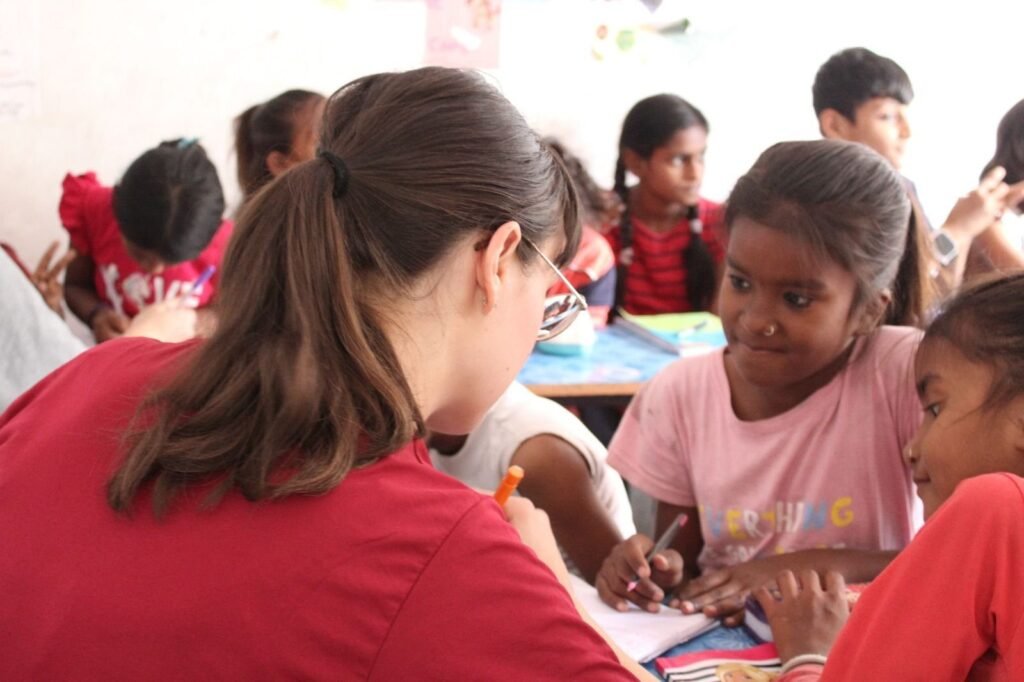 A volunteer helping girls with an art lesson in Jaipur