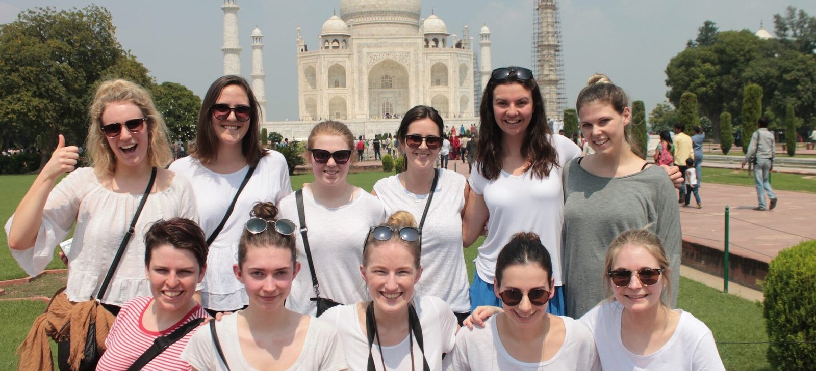 A group of volunteers smiling in front of the Taj Mahal