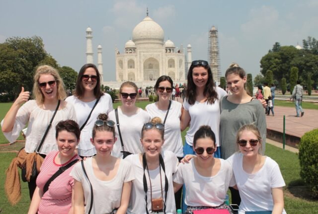 A group of volunteers smiling in front of the Taj Mahal