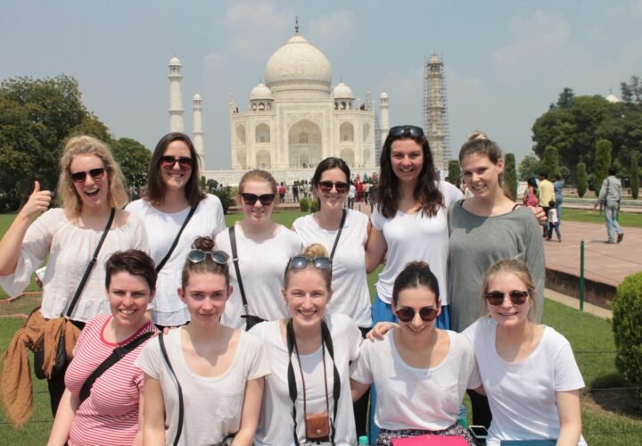 A group of volunteers smiling in front of the Taj Mahal