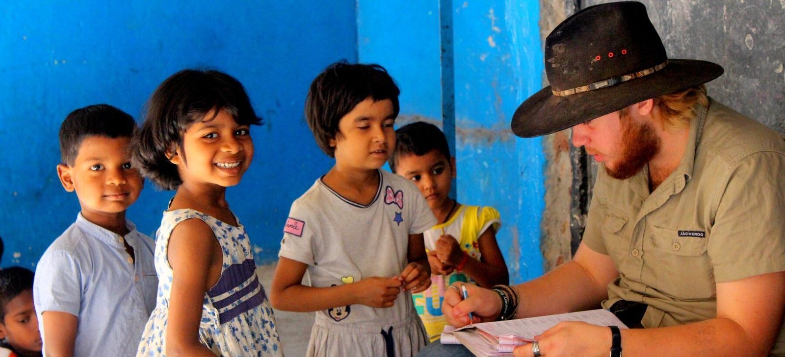 A volunteer going through a worksheet with children at a shelter home in Delhi