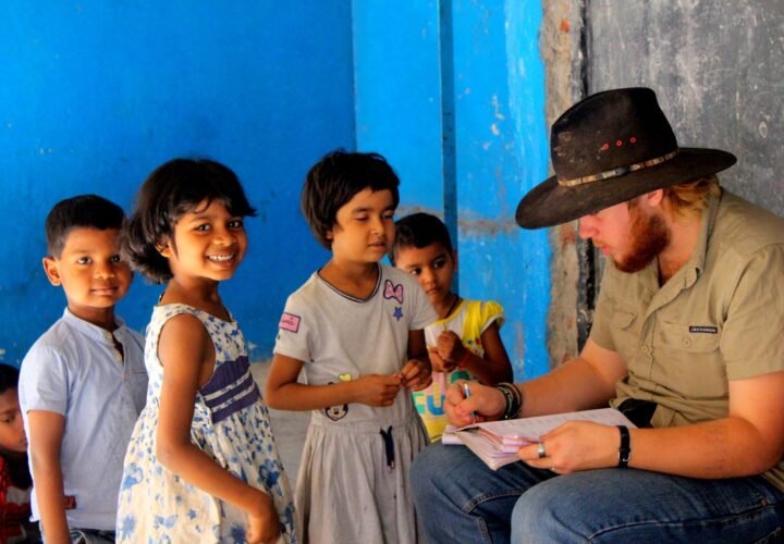 A volunteer going through a worksheet with children at a shelter home in Delhi