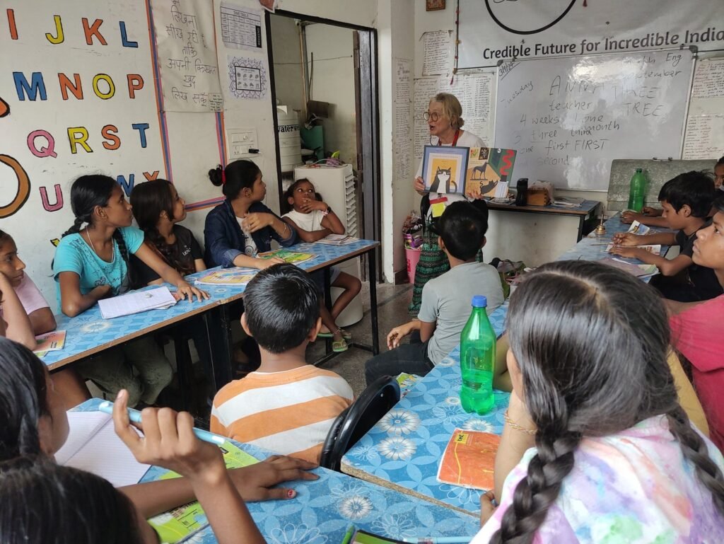A volunteer teaching a class of children at their desks in Jaipur