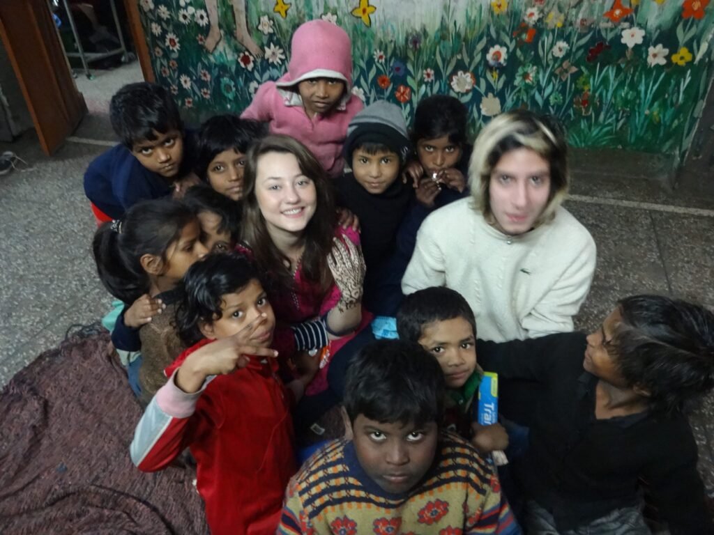 Two volunteers with a group of children at a shelter home in Delhi