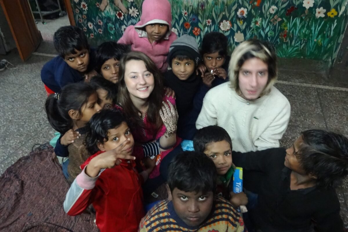 Two volunteers with a group of children at a shelter home in Delhi