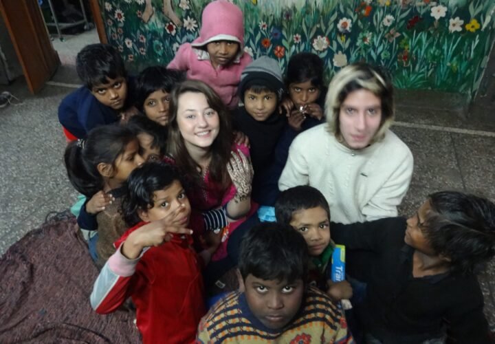 Two volunteers with a group of children at a shelter home in Delhi