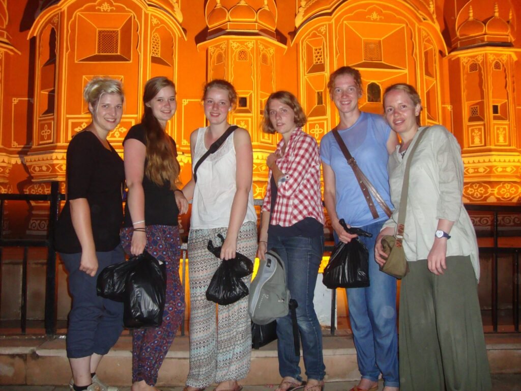 Volunteers in front of the lit-up Hawa Mahal in Jaipur at night