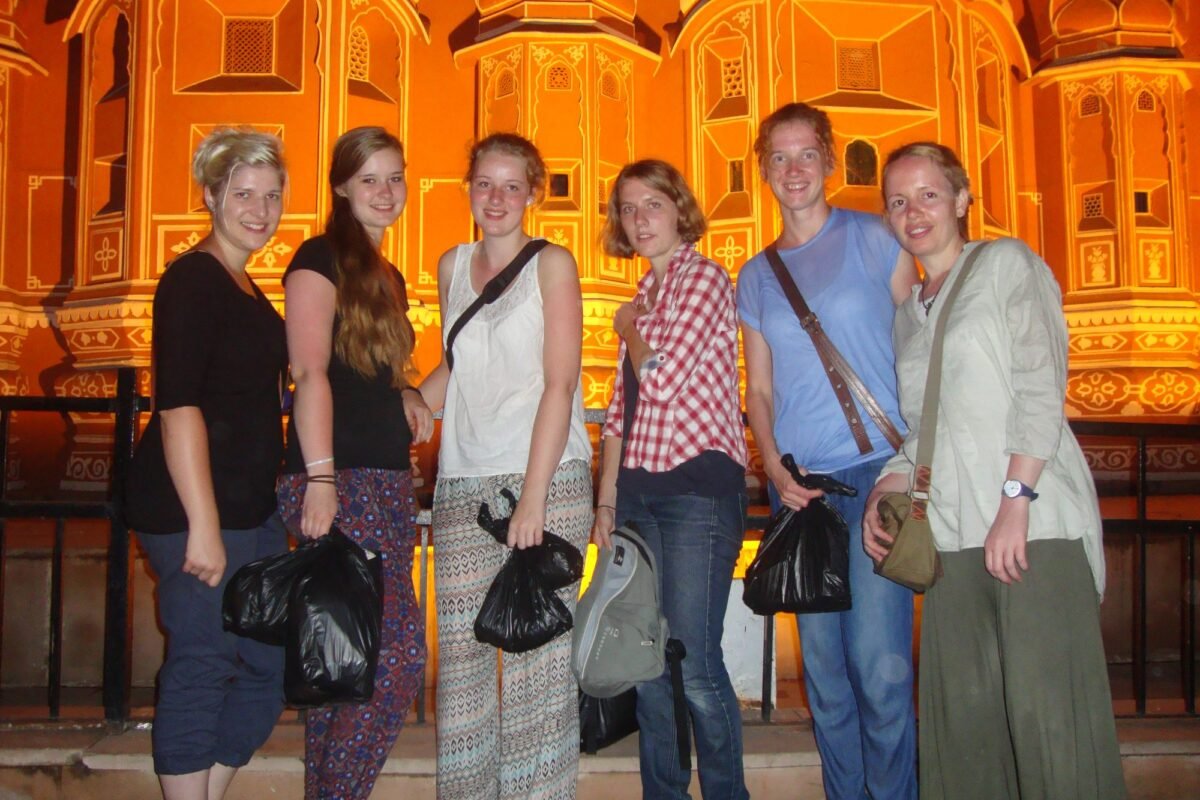 Volunteers in front of the lit-up Hawa Mahal in Jaipur at night
