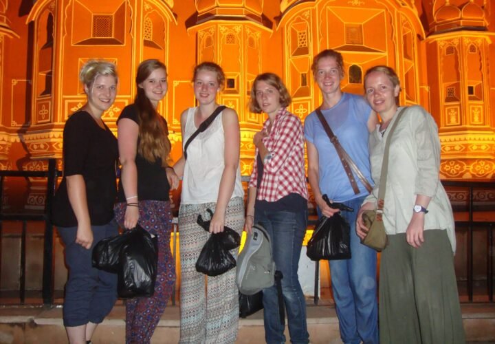 Volunteers in front of the lit-up Hawa Mahal in Jaipur at night