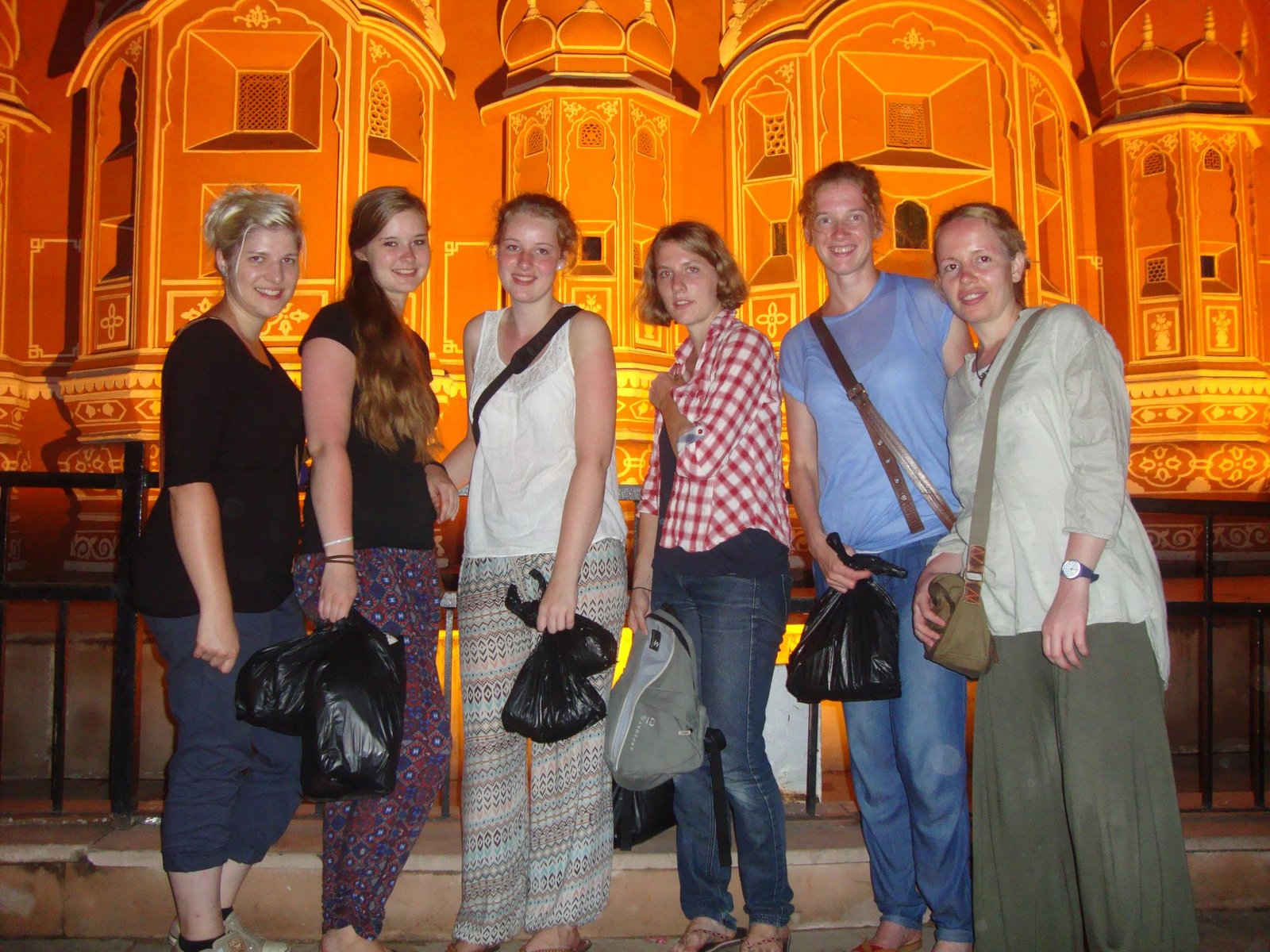 Volunteers in front of the lit-up Hawa Mahal in Jaipur at night