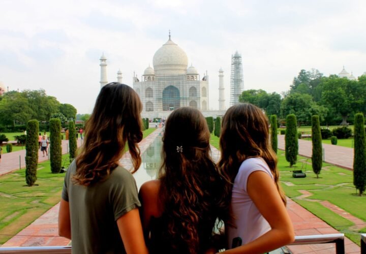 Three volunteers looking at the Taj Mahal from the garden path in Agra
